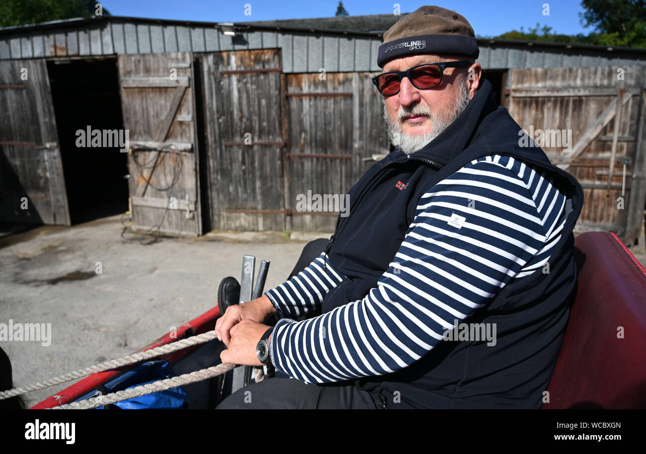 Cuxhaven, Germany. 16th Aug, 2019. Wattwagenführer Fred Meier-Klocker sits on his carriage in the yard. He parodies Schlager as Freddy Caruso. Now he has discovered a passion: as a wagon driver he brings tourists from Cuxhaven to Neuwerk. Credit: Carmen Jaspersen/dpa/Alamy Live News Stock Photo