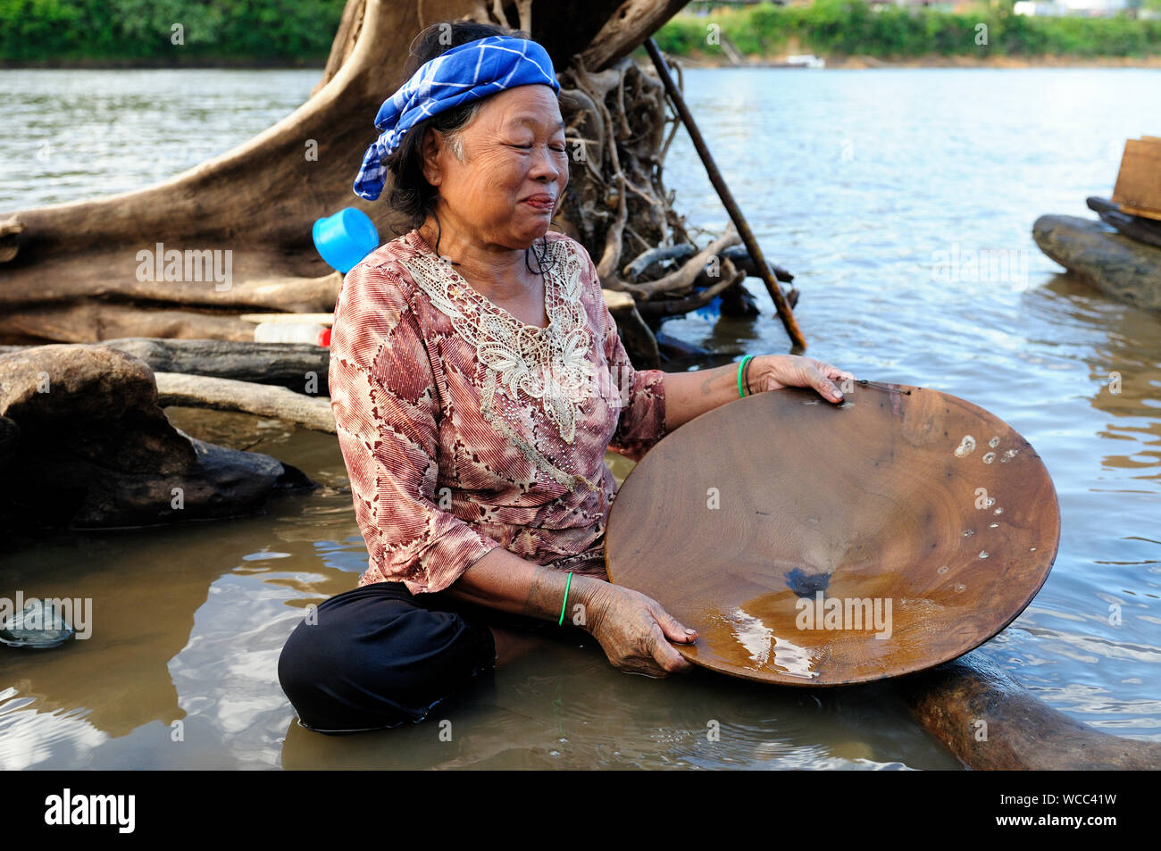 LONG BAGUN, BORNEO, INDONESIA - JULY 03: The older Dayak women - the golden searcher is rinsing sand in the river in prospecting for gold from Borneo Stock Photo