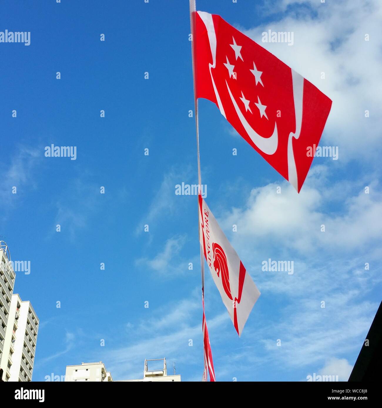 Low Angle View Of Singaporean Flag Against Sky Stock Photo