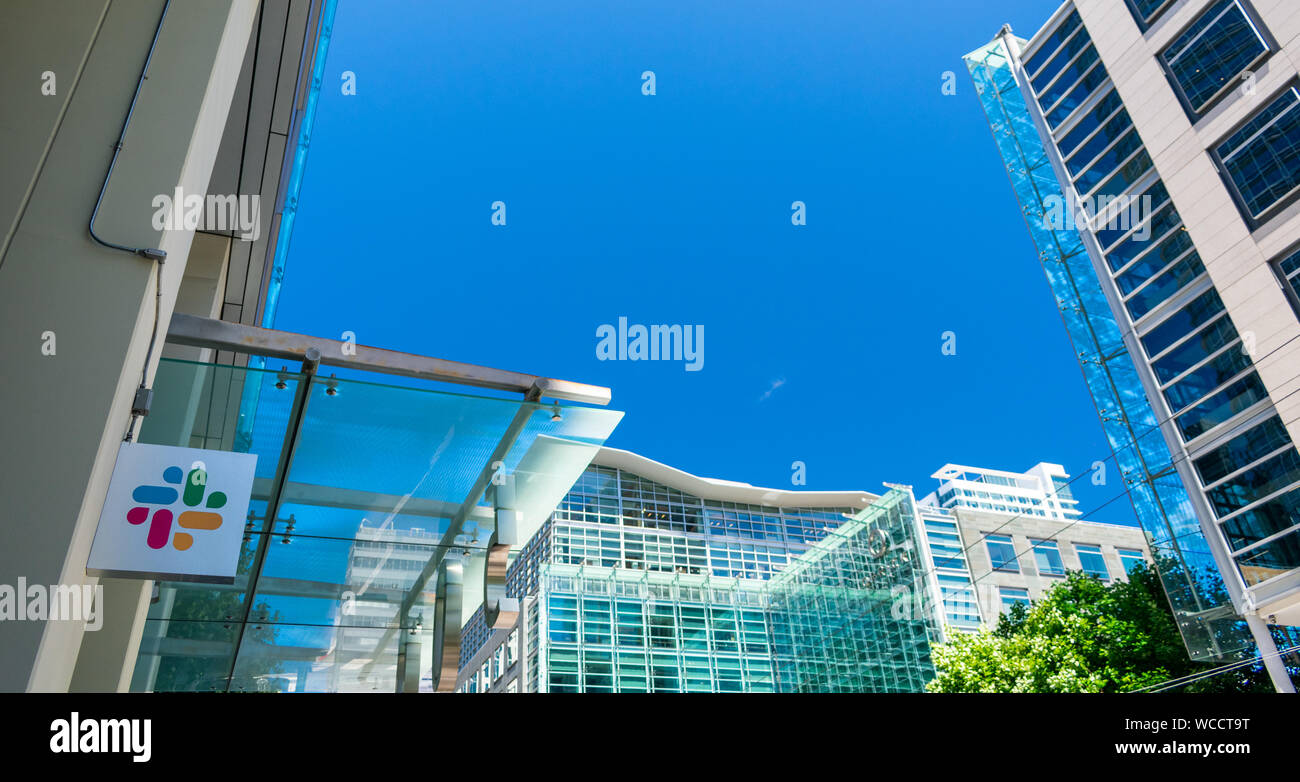 Slack Technologies logo on facade of software company headquarters with high rise cityscape background Stock Photo