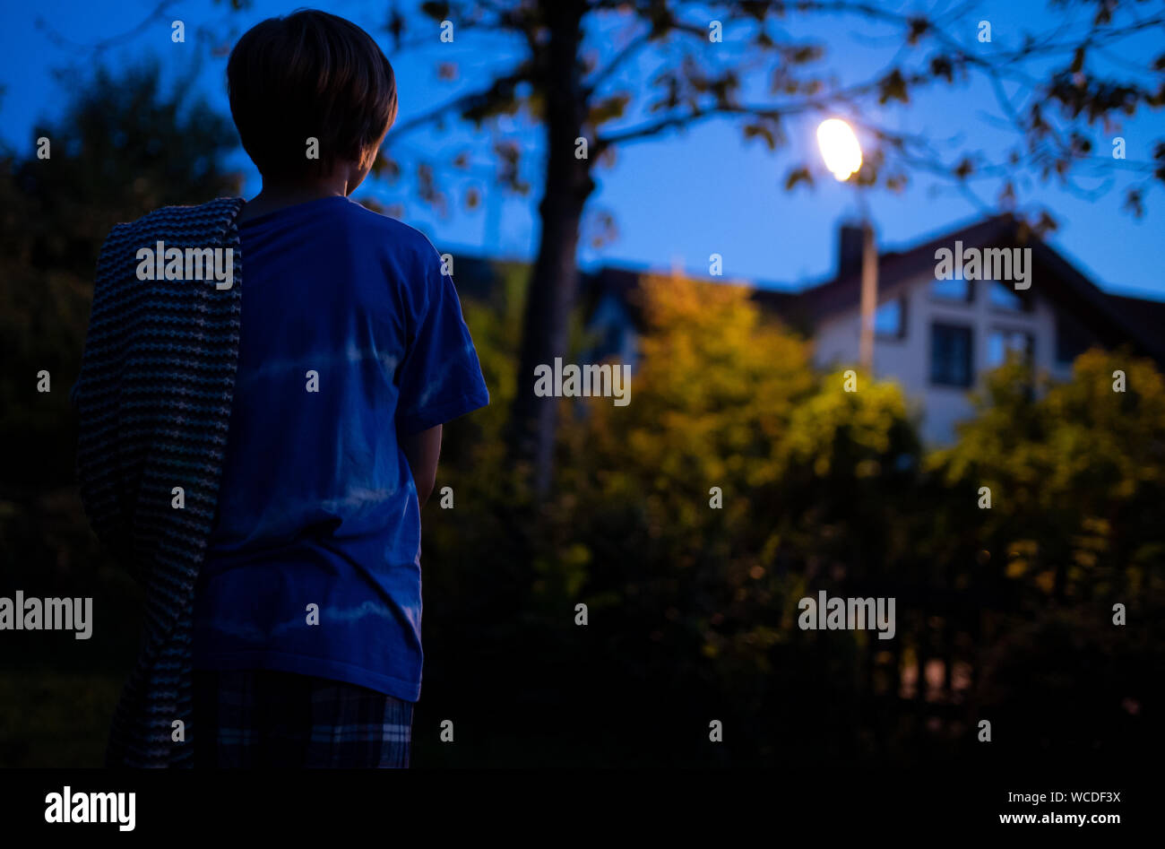 Munich, Germany. 27th Aug, 2019. ILLUSTRATION - A boy in pyjamas stands in the garden at night with a blanket. While others sleep deeply and firmly, they often reach top form, albeit involuntarily: sleepwalkers. They go for walks, drive cars, eat, clean, cook and some even become violent. Credit: Sven Hoppe/dpa/Alamy Live News Stock Photo