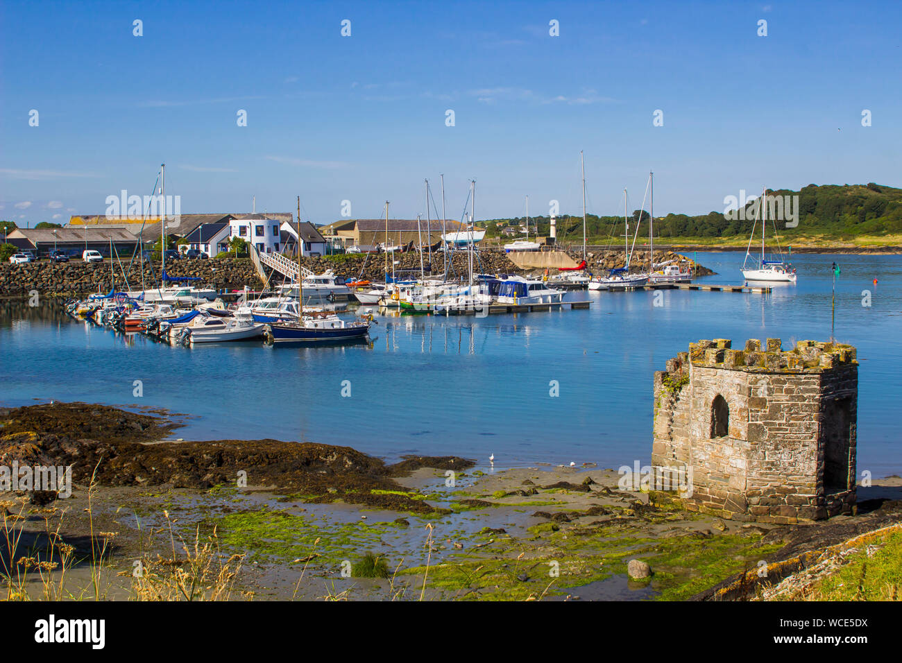 8 august 2019 A small medieval stone tower overlooking the marina and harbour at Ardglass County Down northern Ireland on a hot day in summer Stock Photo
