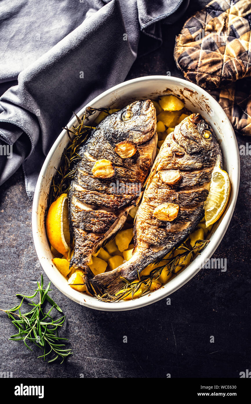 Roasted mediterranean fish bream with potatoes rosemary and lemon Stock Photo