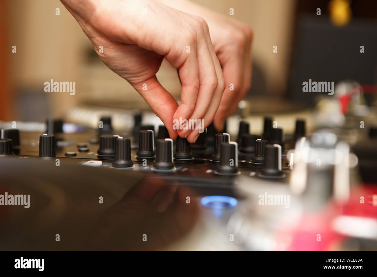Professional hip hop dj mixes tracks on sound mixer controller in night