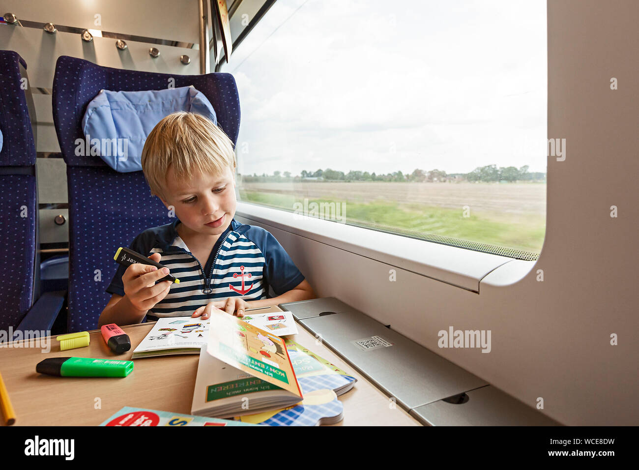 Boy, 6 years, drawing during train journey, GERMANY, 01.08.2019. Stock Photo
