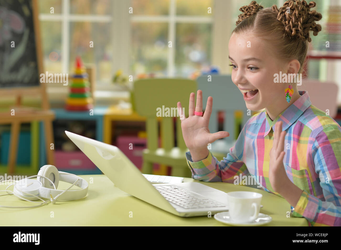 Cute little girl using laptop at her room Stock Photo - Alamy