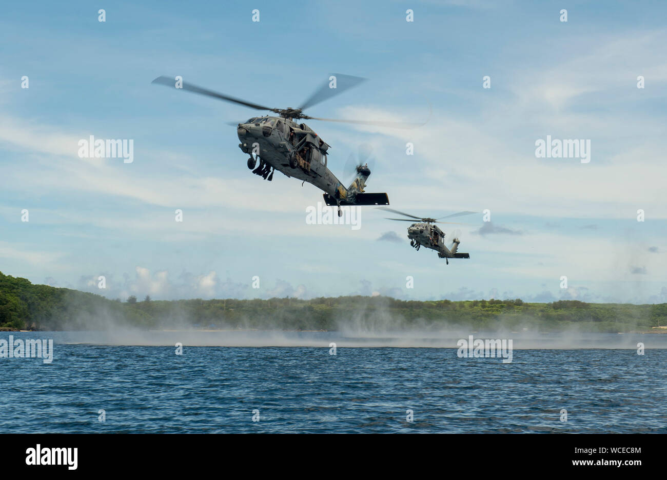 190827-N-QL471-1011  SANTA RITA, Guam (Aug. 27, 2019) MH-60S Seahawk helicopters, attached to the “Island Knights” of Helicopter Sea Combat Squadron (HSC) 25, carry U.S. Marines, assigned to 3rd Reconnaissance Battalion, 3rd Marine Division and 3rd Marine Division, Explosive Ordnance Disposal 1st Platoon, and members of Her Majesty’s New Zealand Ship Matataua (HMNZS Matataua) during a helocasting subject matter expert knowledge exchange as part of Exercise HYDRACRAB. HYDRACRAB is a quadrilateral exercise conducted by forces from Australia, Canada, New Zealand, and U.S. Naval forces. The purpos Stock Photo