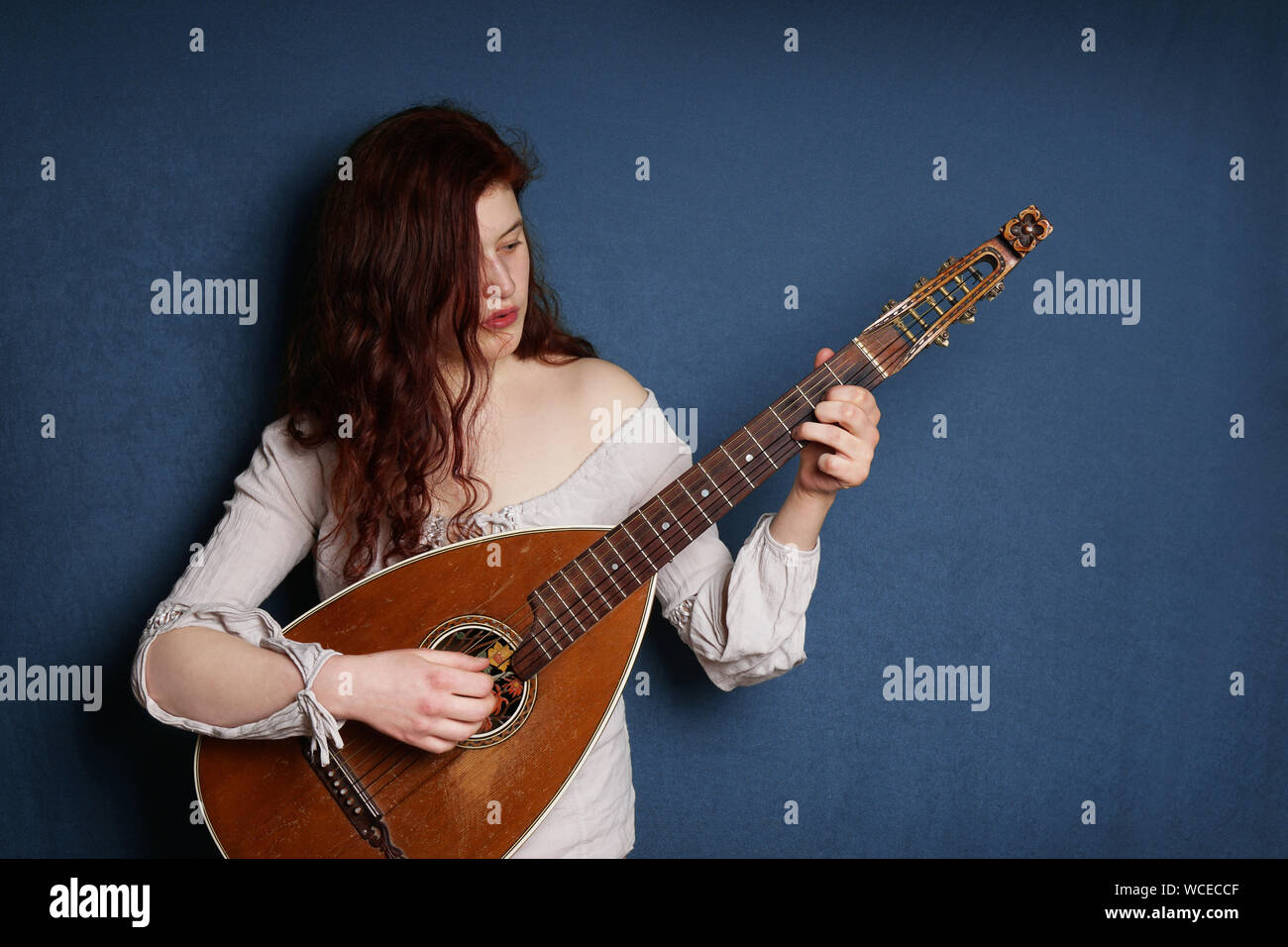 images Female Lute Player https www alamy com young woman playing lute against blue wall image265848479 html