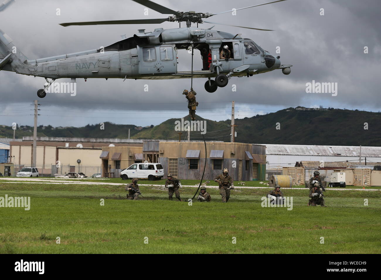 U.S. Marines with 3rd Reconnaissance Battalion, 3rd Marine Division, conduct helicopter rope suspension training from a MH-60S Seahawk helicopter during exercise HYDRACRAB in Santa Rita, Guam, Aug. 19, 2019. HYDRACRAB is a multilateral exercise conducted by U.S. Marines and Sailors with military service members from Australia, Canada, and New Zealand. The purpose of this exercise is to prepare the participating Explosive Ordnance Disposal forces to operate as an integrated, capable, and effective allied force ready to operate in a changing and complex maritime environment throughout the Indo-P Stock Photo