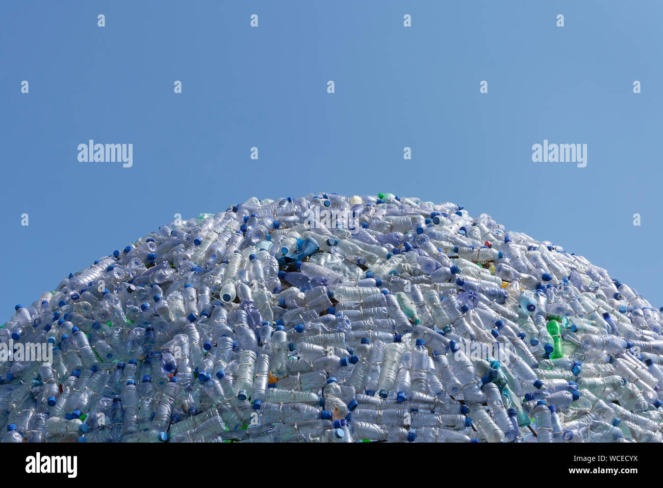 semicircular mountain of plastic waste, plastic bottles with a beautiful blue background Stock Photo