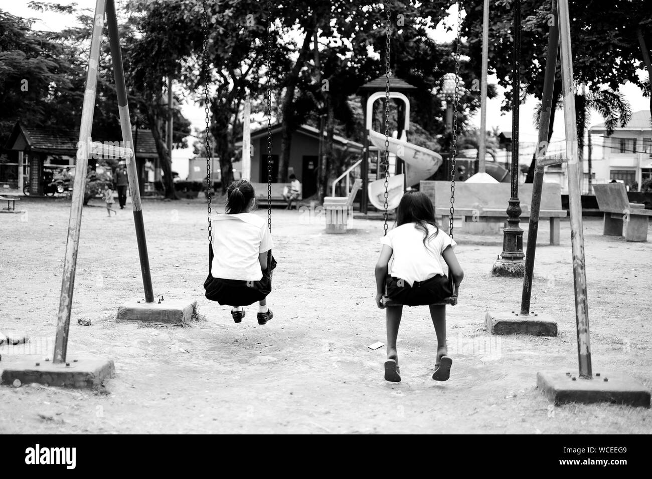 Two girls on swing Black and White Stock Photos & Images - Alamy