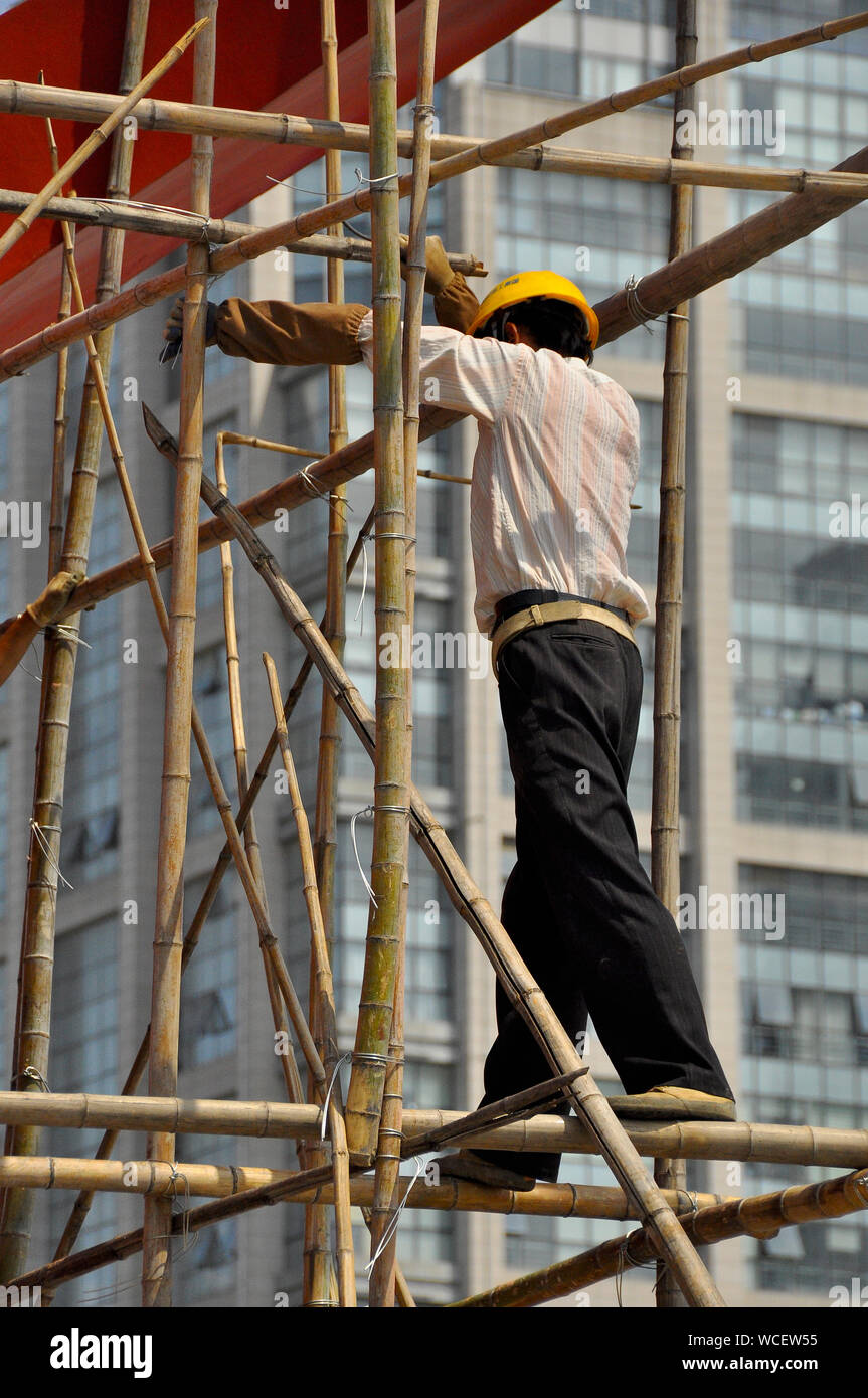 Construction workers climb bamboo scaffolding in Nantong China Stock Photo