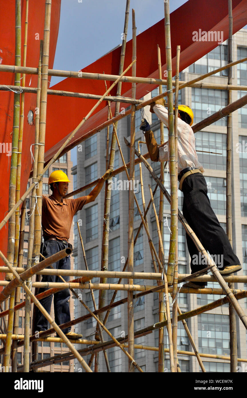 Construction workers climb bamboo scaffolding in Nantong China Stock Photo