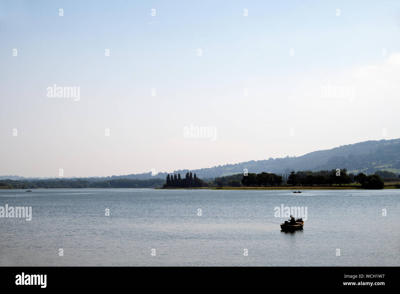 Fisherman in boat on Blagdon lake Somerset in England Stock Photo