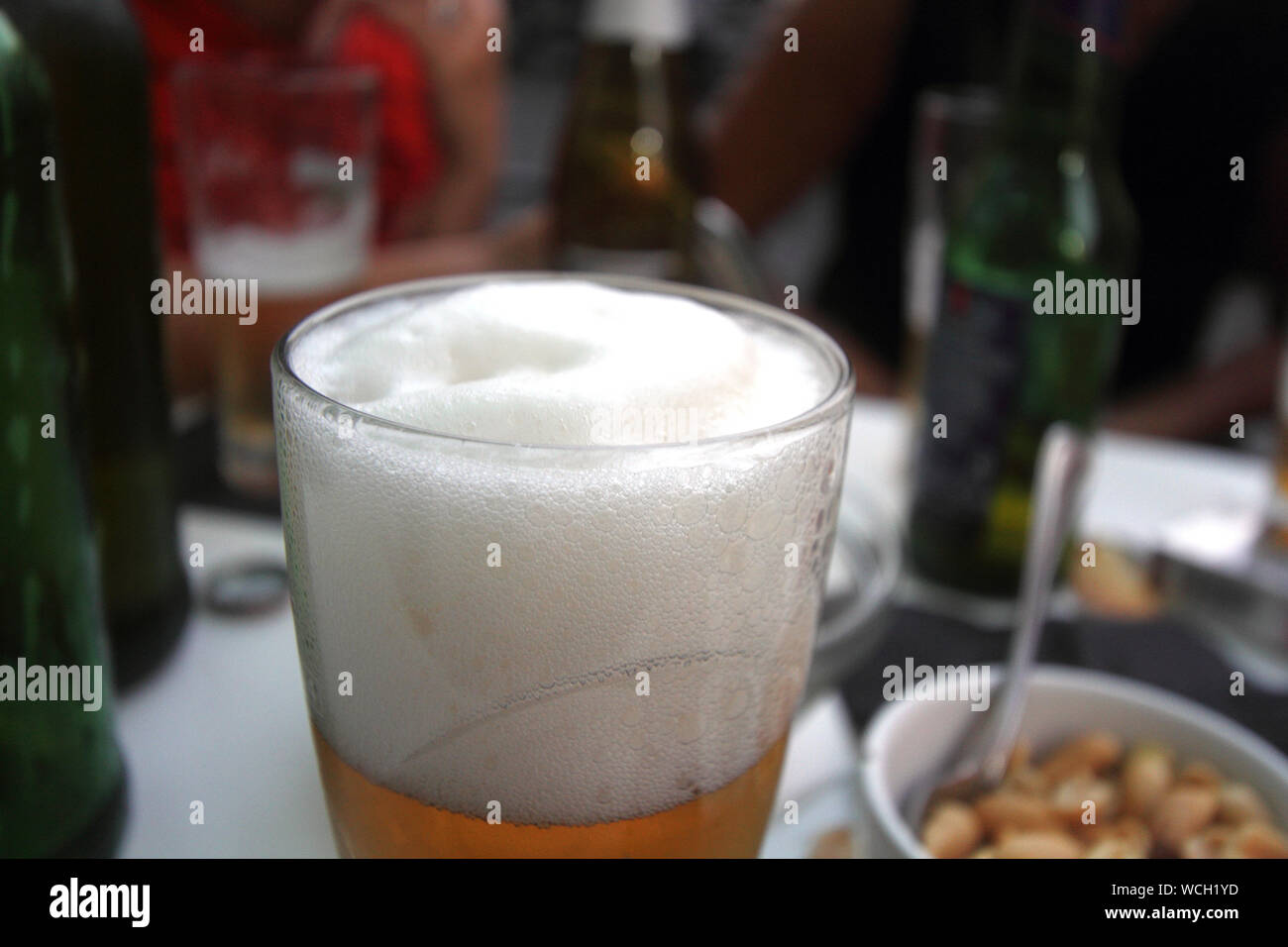 table with aperitif and snack bar, close up on glass of beer Stock Photo