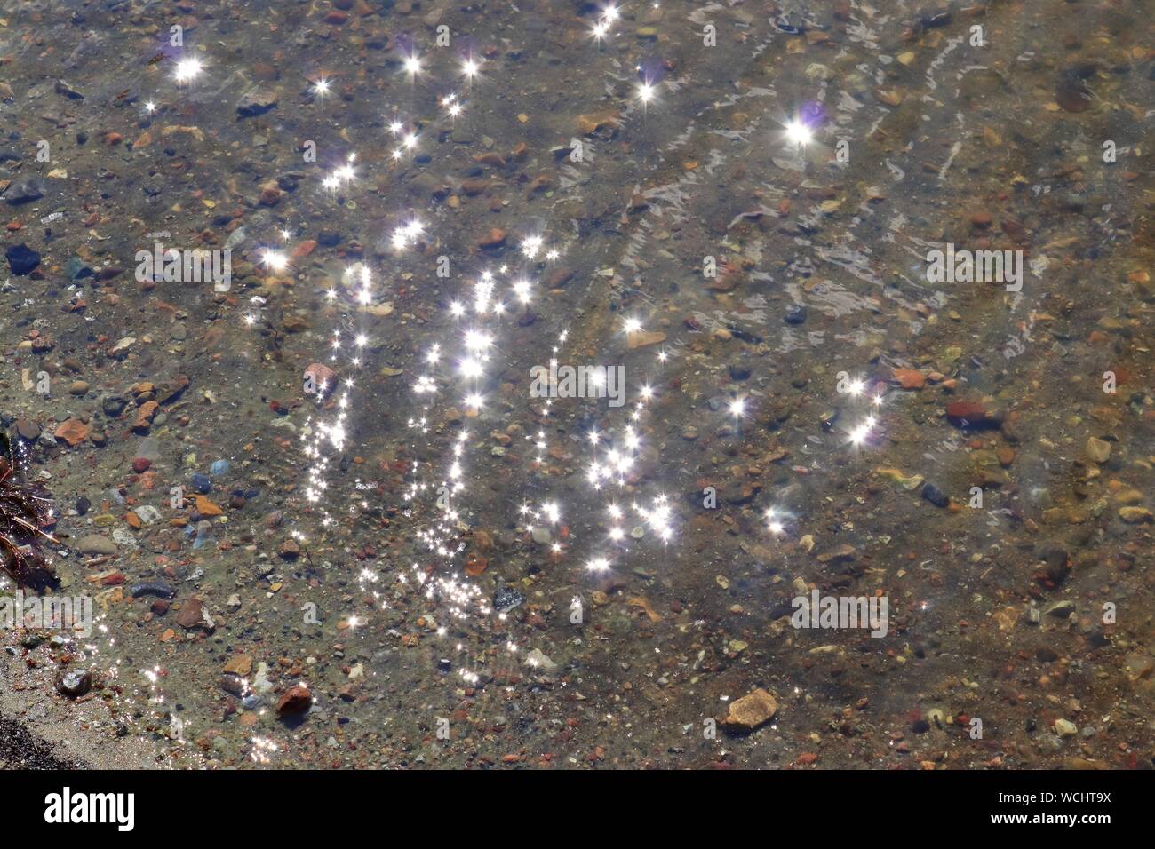 Reflection View Detailed close up view on water surface with reflection sunlight at the ...