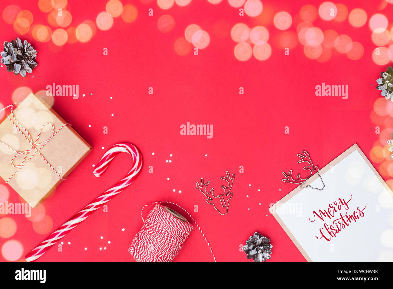 Christmas flat lay with gift box, candy cone and other small elements and place for text. Light effect. Stock Photo