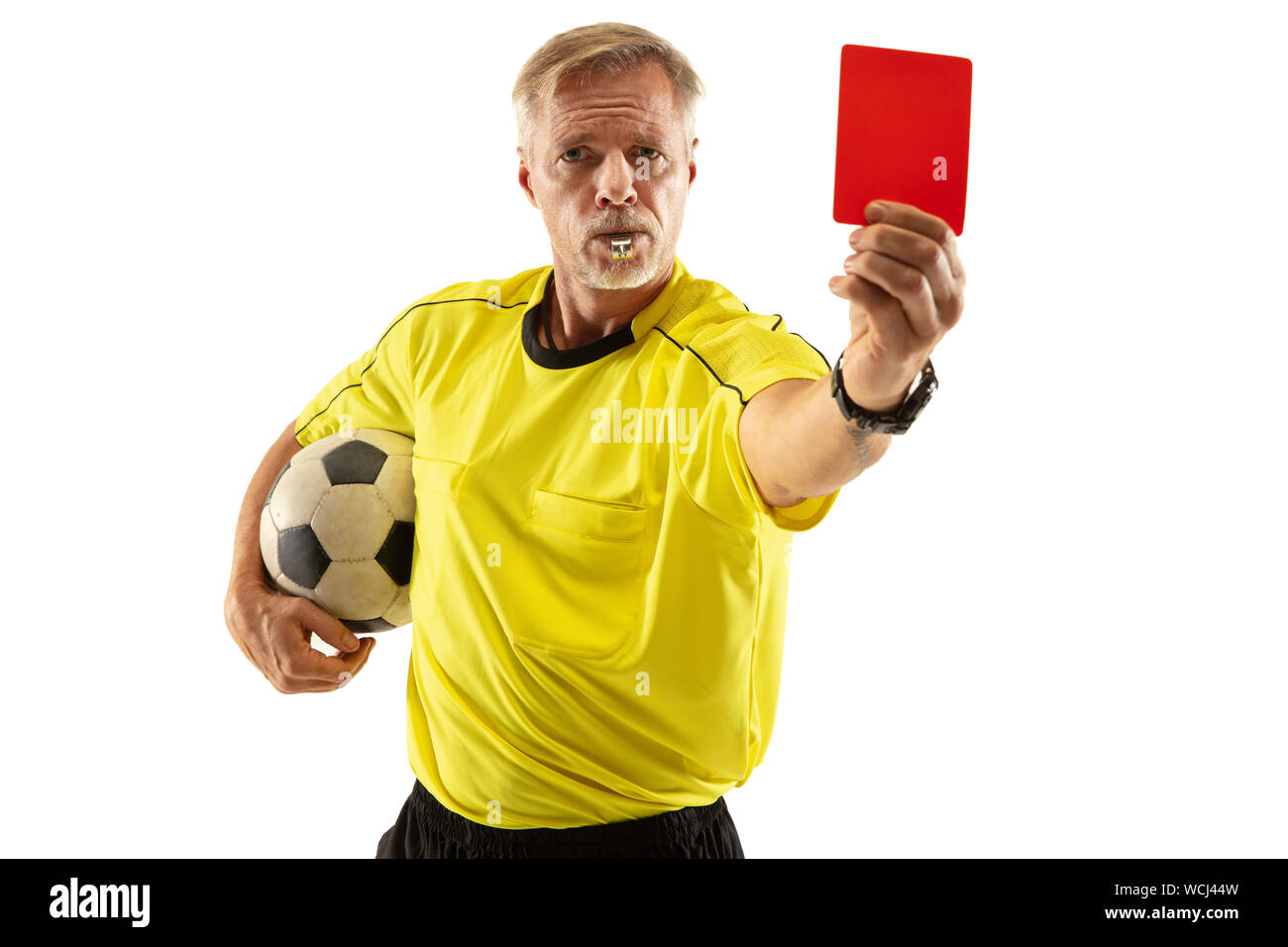 Referee holding ball and showing a red card to a football or soccer
