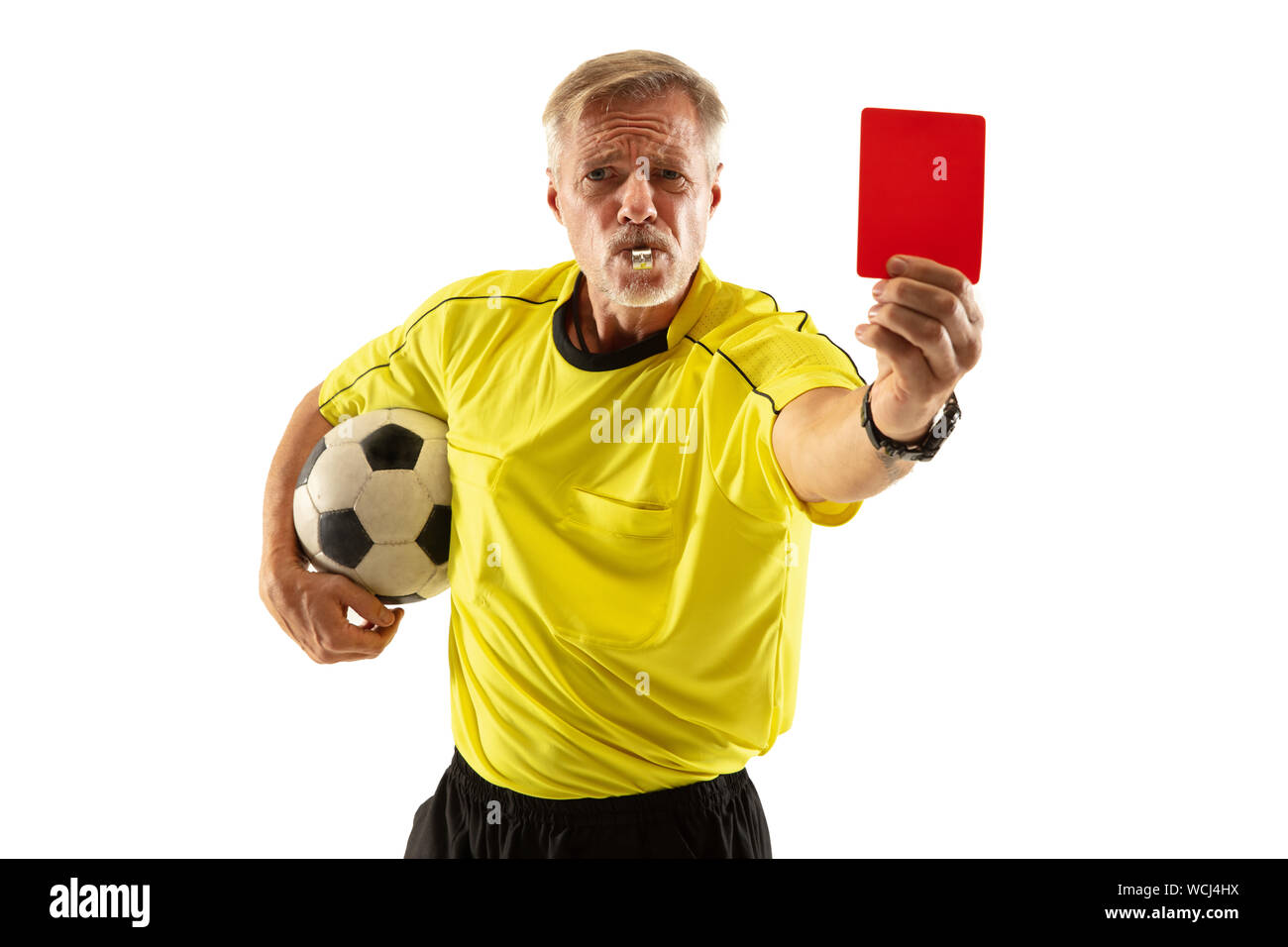 referee holding ball and showing a red card to a football or soccer player while gaming on white studio background concept of sport rules violation controversial issues obstacles overcoming WCJ4HX