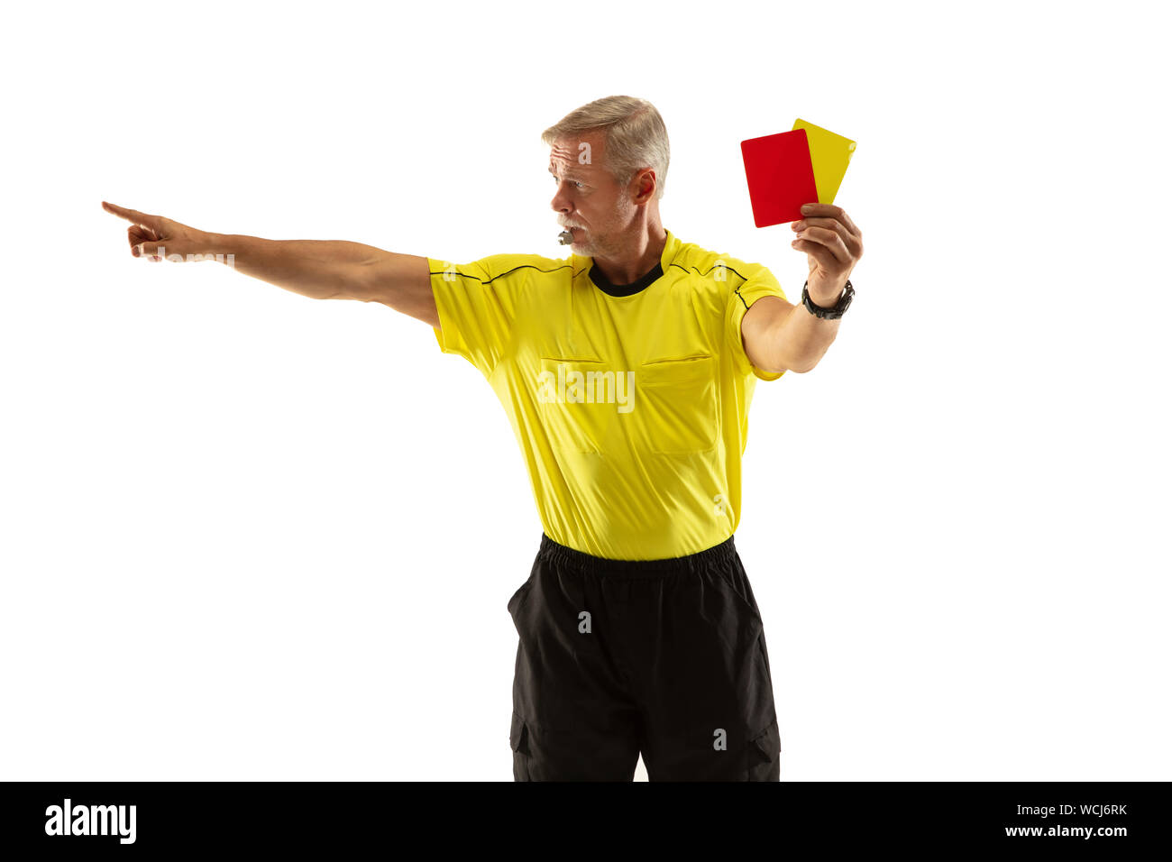 Referee showing a red and yellow cards to a football or soccer player while gaming on white studio background. Concept of sport, rules violation, controversial issues, obstacles overcoming. Stock Photo