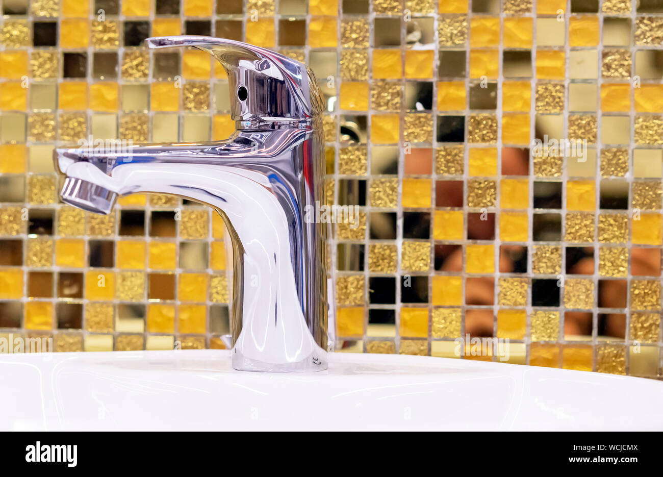 Water Supply Faucet Mixer On The Background Of Yellow Ceramic