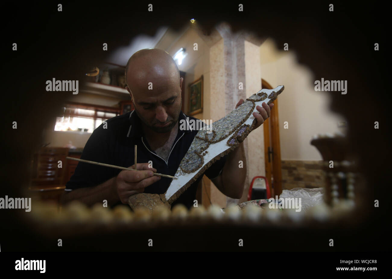 Gaza. 28th Aug, 2019. Kamal al-Madhoun makes an art piece with seashells at his house in Nusseirat refugee camp in the central Gaza Strip, Aug. 28, 2019. Kamal al-Madhoun, a 43-year-old Palestinian man, began the hobby of seashell art about 20 years ago. Using seashells collected from Gaza beaches, he has made various art pieces. Credit: Khaled Omar/Xinhua Stock Photo