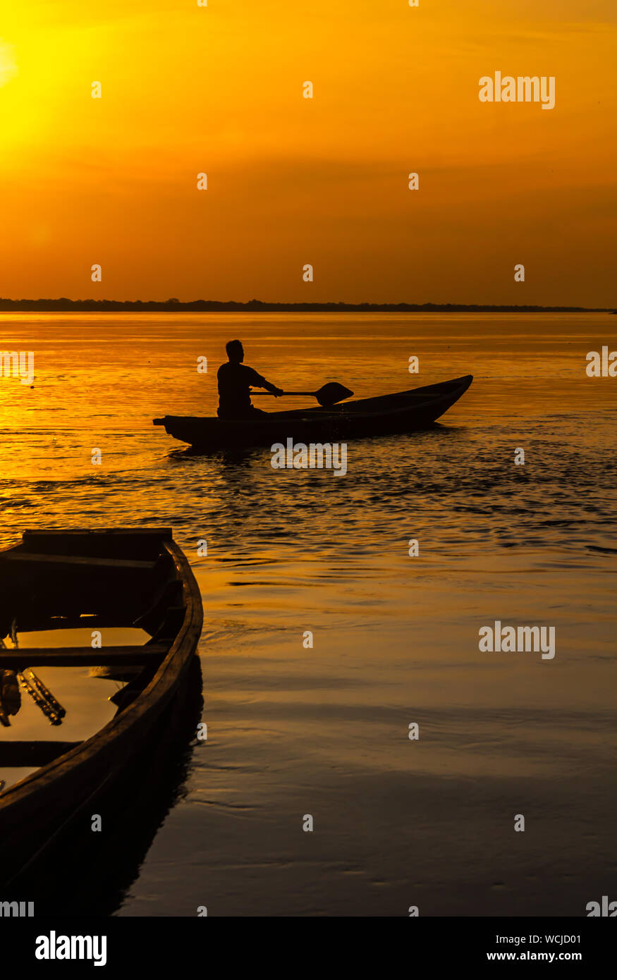 A traditional Peruvian boat, a canoe called Peke Peke, used in the  Amazonian jungle. View during sunset, Amazon river. The man is sailing a  typical b Stock Photo - Alamy