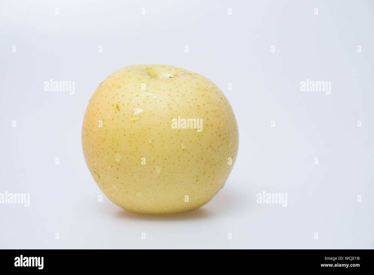 Close-up Of Golden Delicious Apple Against White Background Stock Photo