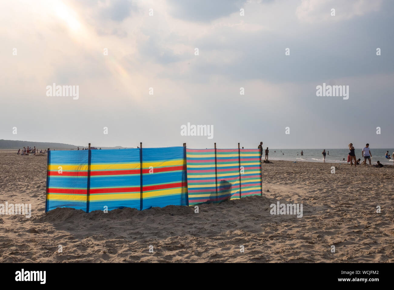 Multicoloured windbreak on Holkham Beach, North Norfolk, UK Stock Photo