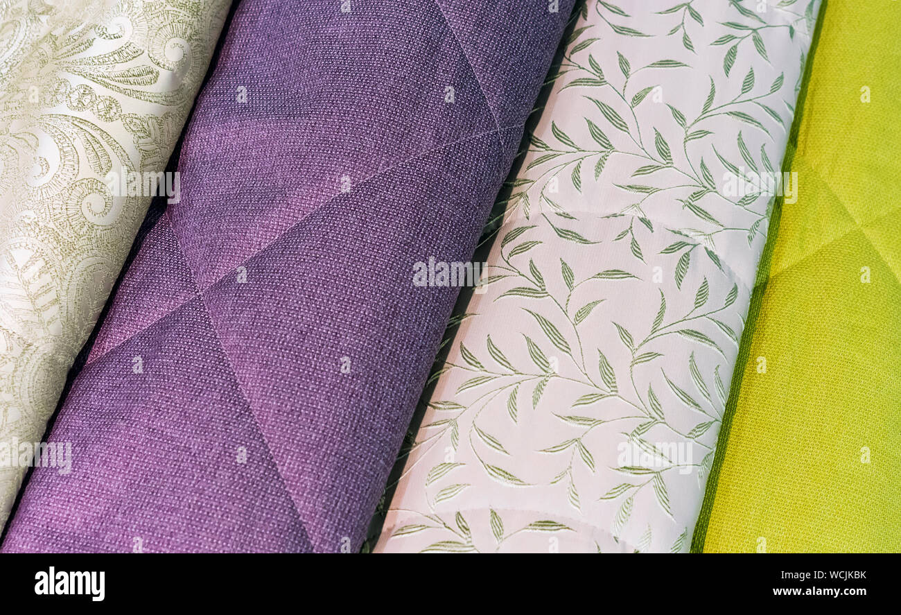 Bedspreads in different colors. Background from fabric of different colors. Stock Photo