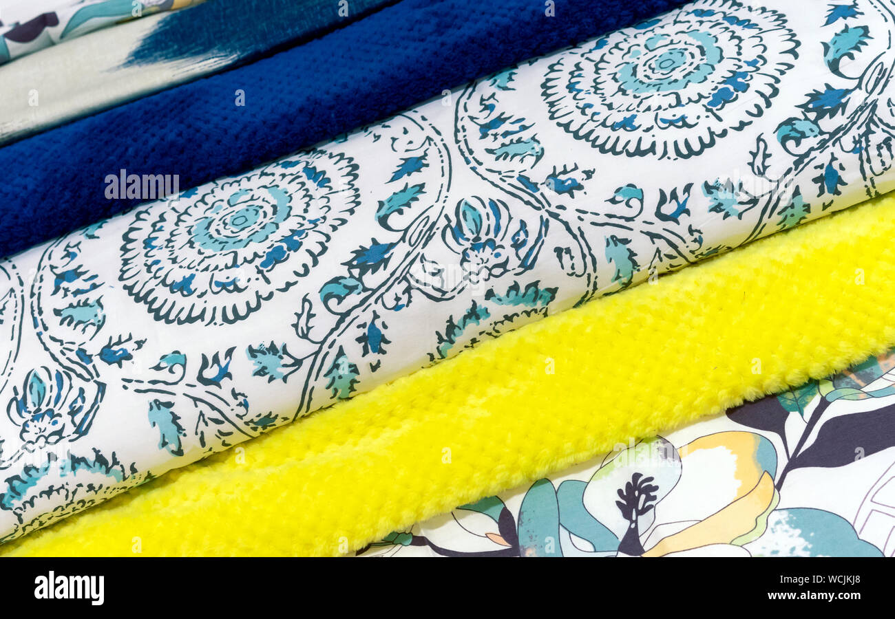 Bedspreads in different colors. Background from fabric of different colors. Stock Photo
