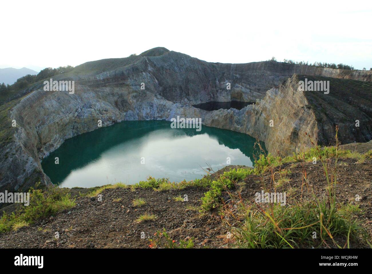 Volcanic Crater Filled With Clear Turquoise Water Stock Photo