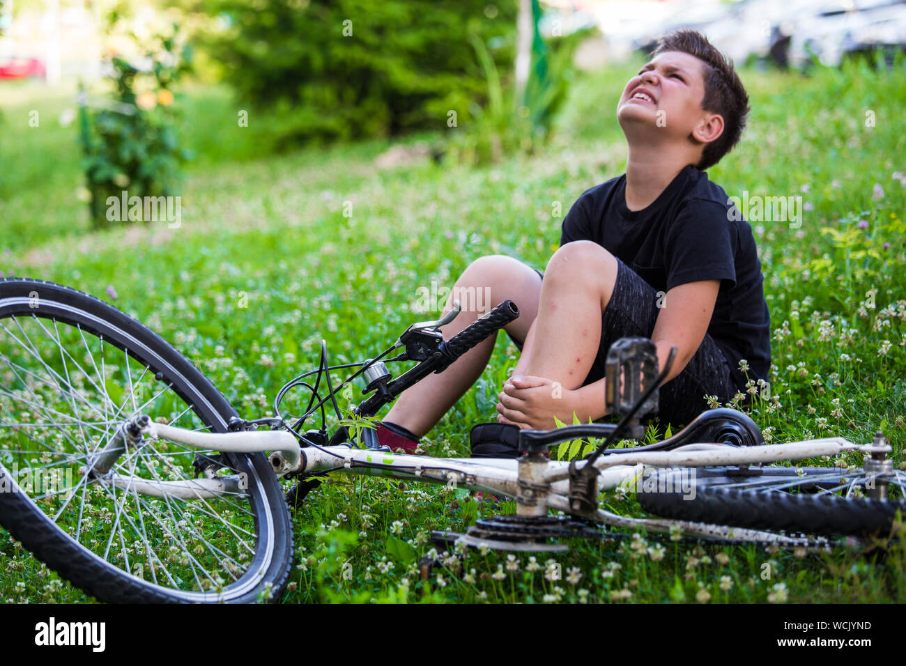 Concept bike accident, Young boy with pain in knee joints after biking