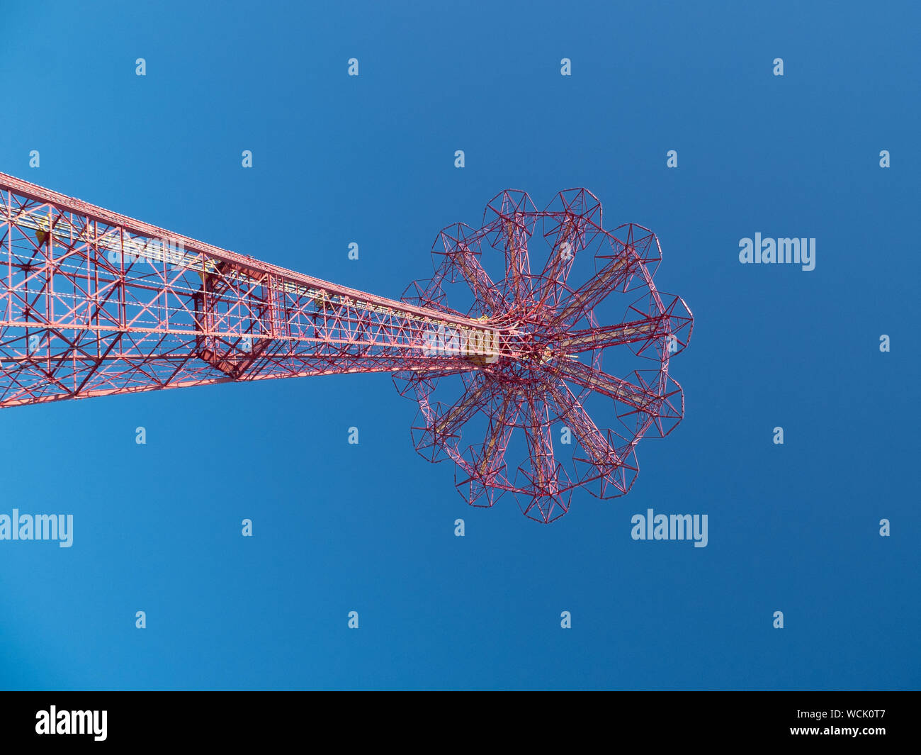 Low Angle View Of Parachute Jump Against Clear Blue Sky Stock Photo