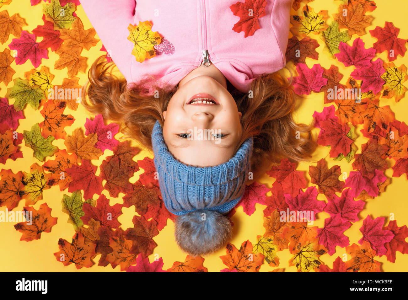 Top view of a happy child lying on the autumn leaves. Stock Photo