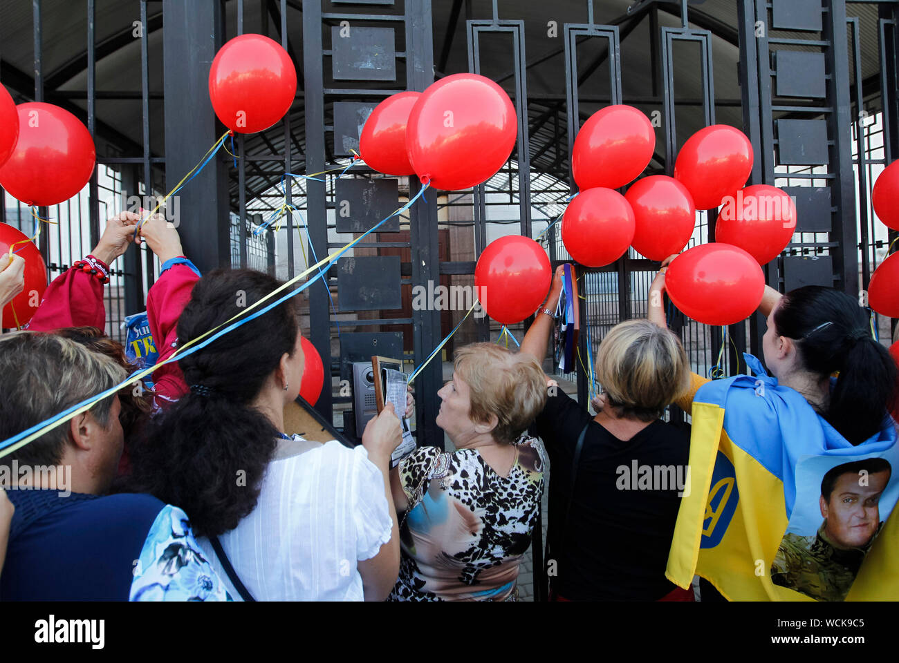 Kiev, Ukraine. 28th Aug, 2019. Relatives set up on a fence of the Russian Embassy symbolic red balloons, during a rally in Kiev.Ukrainians mark the 5th anniversary of Ilovaysk battle on the East of Ukraine, and gathered in memory of lost the Ukrainian soldiers. According to Ukraine officials, 366 Ukrainian soldiers got lost and 158 were missing during heavy fighting between Ukrainian government forces and Russian-backed separatists at the Eastern Ukraine near of Ilovaysk city on August 2014. Credit: SOPA Images Limited/Alamy Live News Stock Photo