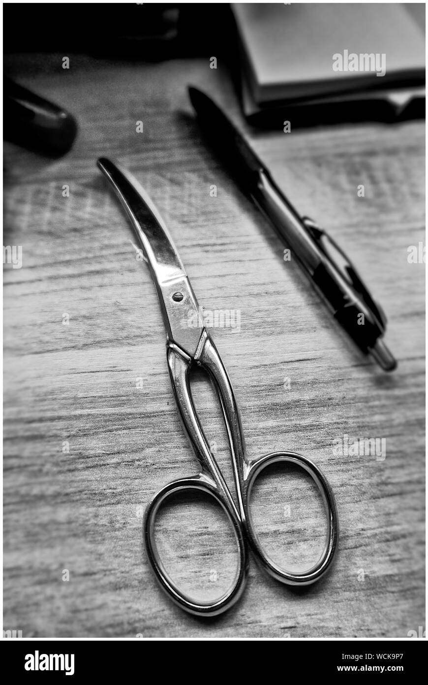 Close-up Of Scissor And Pen On Wooden Table Stock Photo