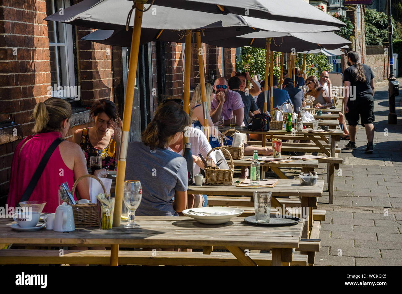 People sit outside at trestle tables outside a gastro pub in Marlow, Buckinghamshire, UK Stock Photo