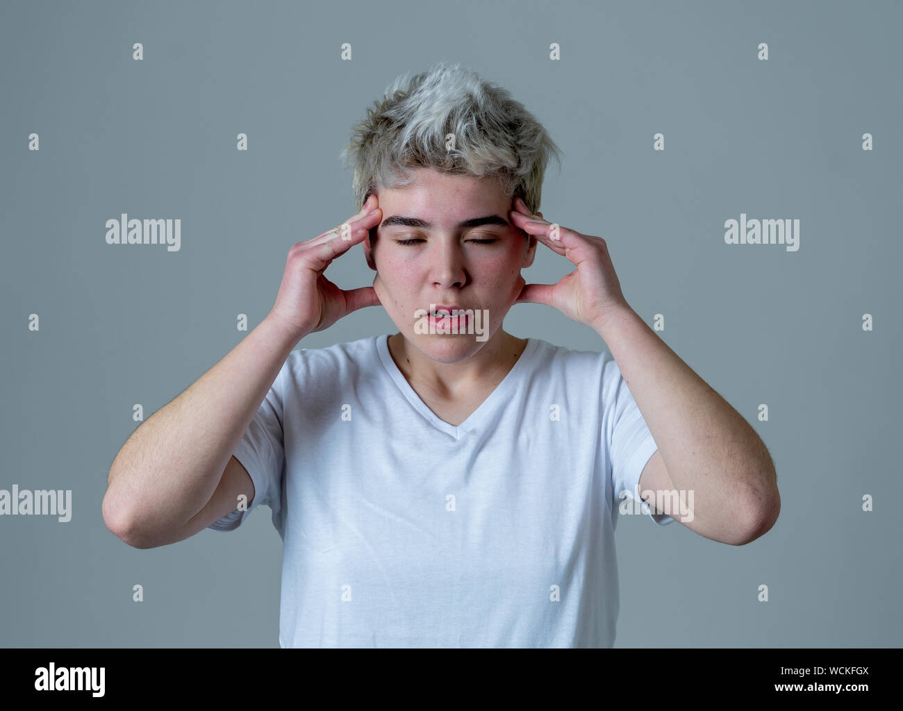 Portrait of a young transgender teen looking worried and thoughtful suffering from migraines and emotional pain. People Diversity gender identity and Stock Photo