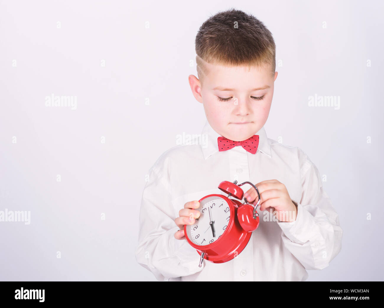 Child little boy hold red clock. It is time. Morning routine. Schoolboy