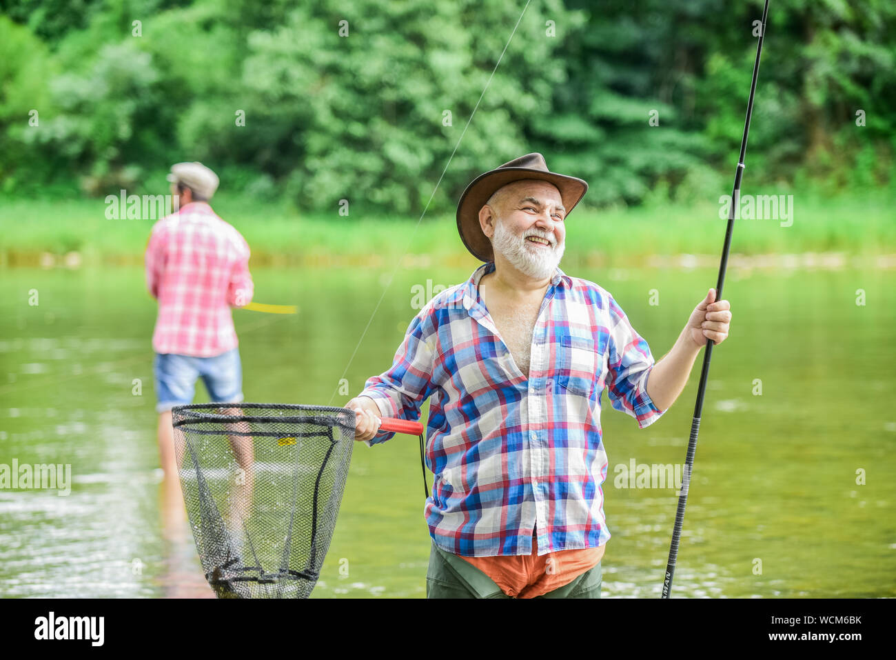 Activity and hobby. Happy cheerful people. Master baiter. Fisherman with fishing  rod. Fishing freshwater lake pond river. Bearded men catching fish. Mature  man with friend fishing. Summer vacation Stock Photo - Alamy