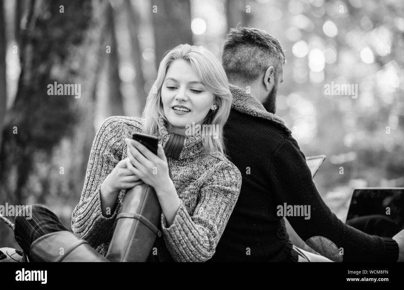 Modern people always involved online communication. Online life modern technology. Logout of all accounts. Modern life. Happy loving couple relaxing in park with mobile gadgets. Internet addiction. Stock Photo