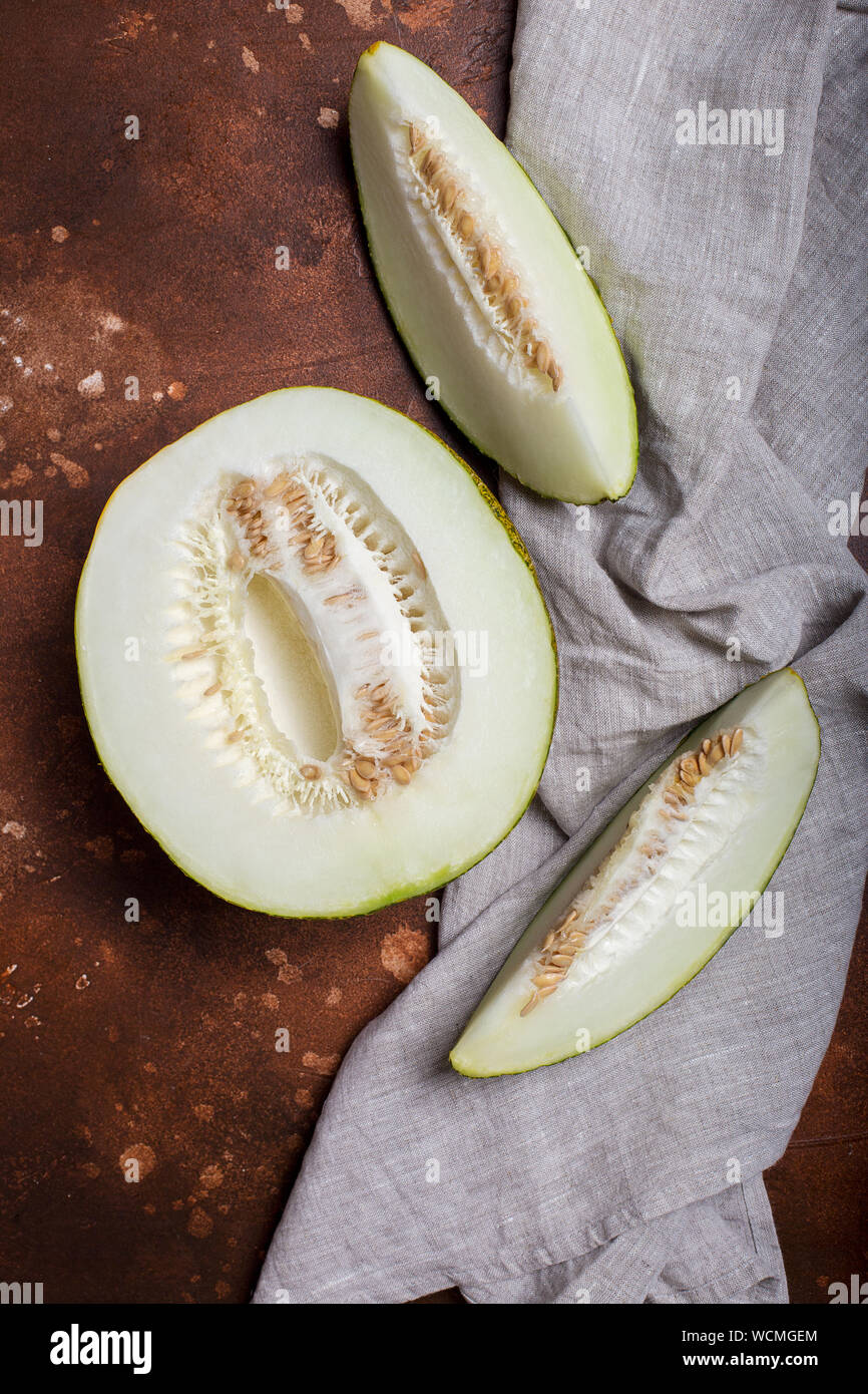 Slices of melon with napkin on brown background. Concept of raw vegan food Stock Photo
