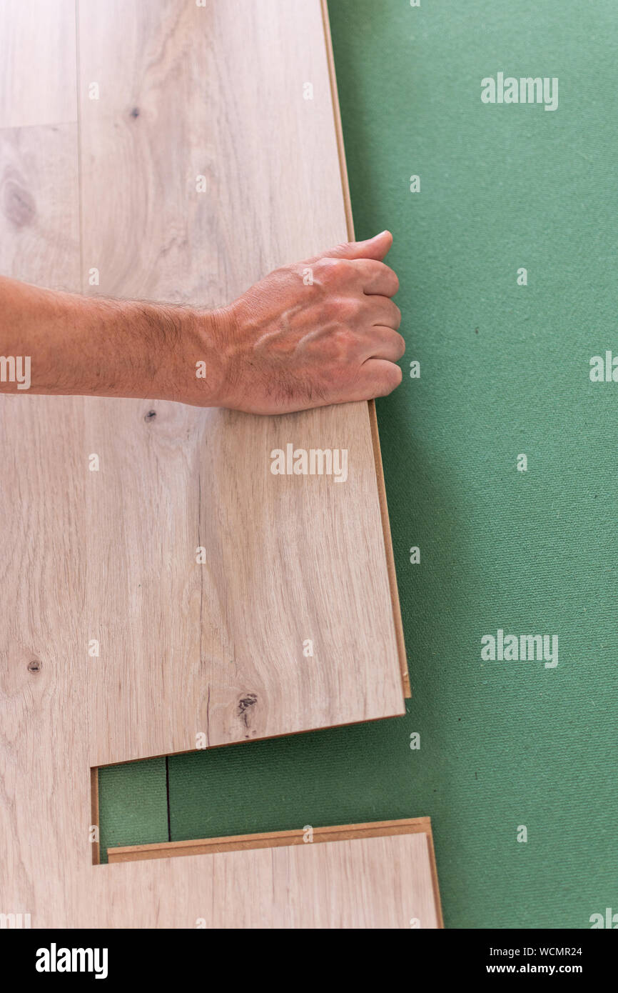Installation laminate or parquet in the room, worker installing wooden laminate flooring