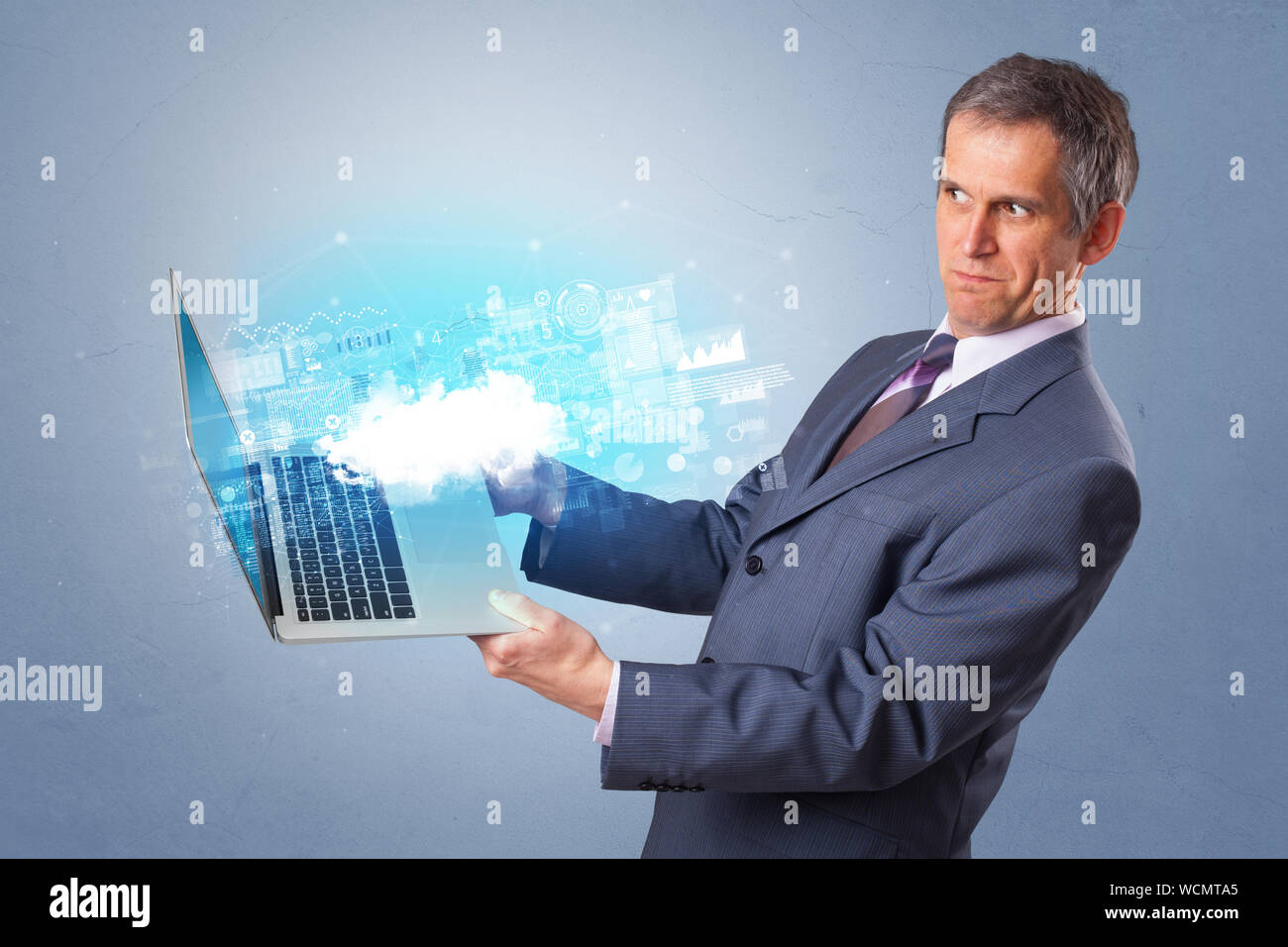 Man holding laptop projecting notifications, symbols and information based on cloud technology system Stock Photo