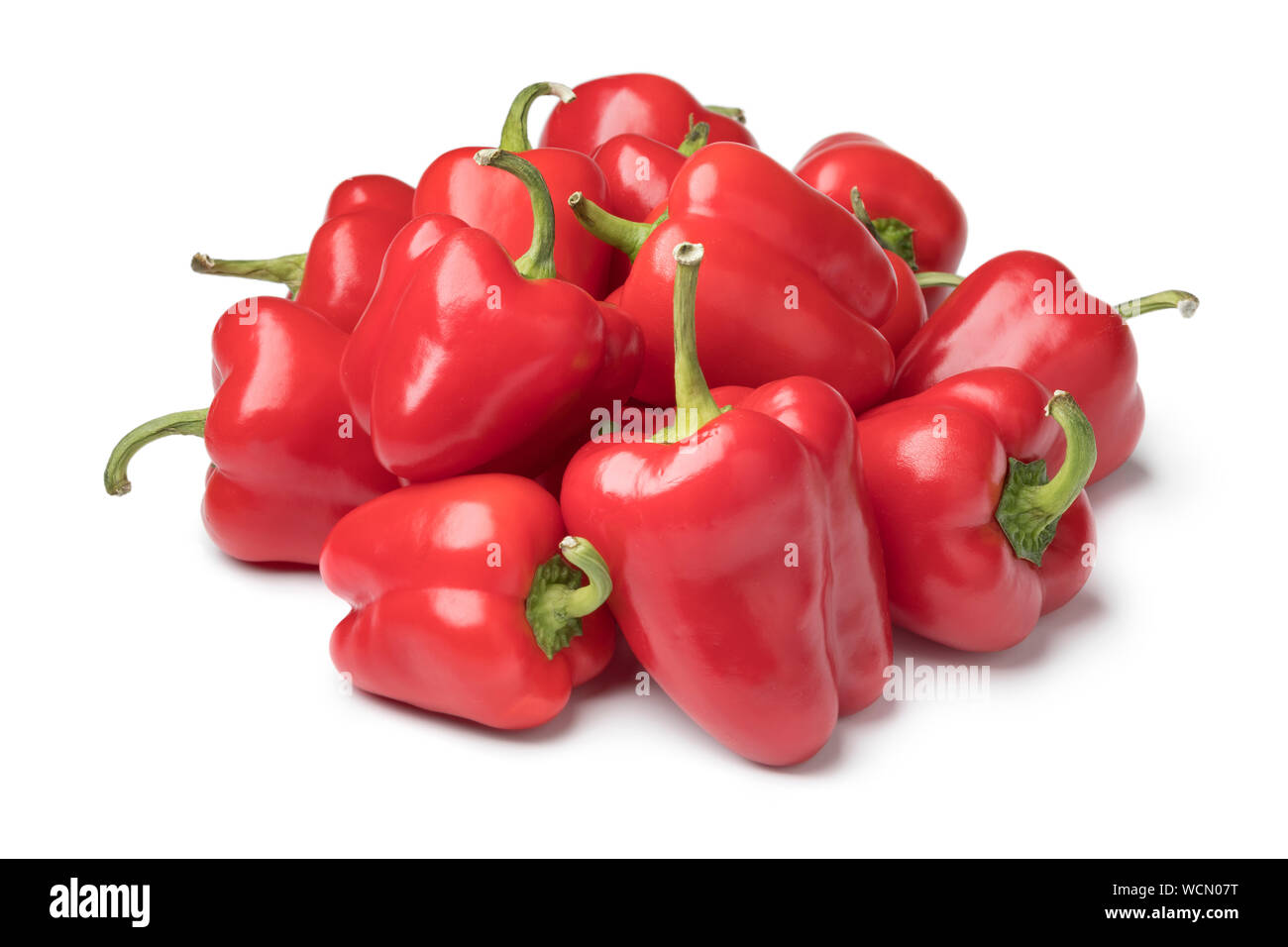 Heap of fresh raw mini red bell peppers isolated on white background Stock Photo