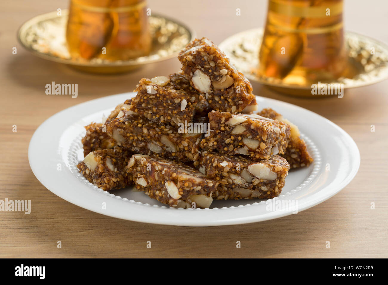 Dish with Turkish fig, fruit and nut cake pieces served with traditional tea Stock Photo