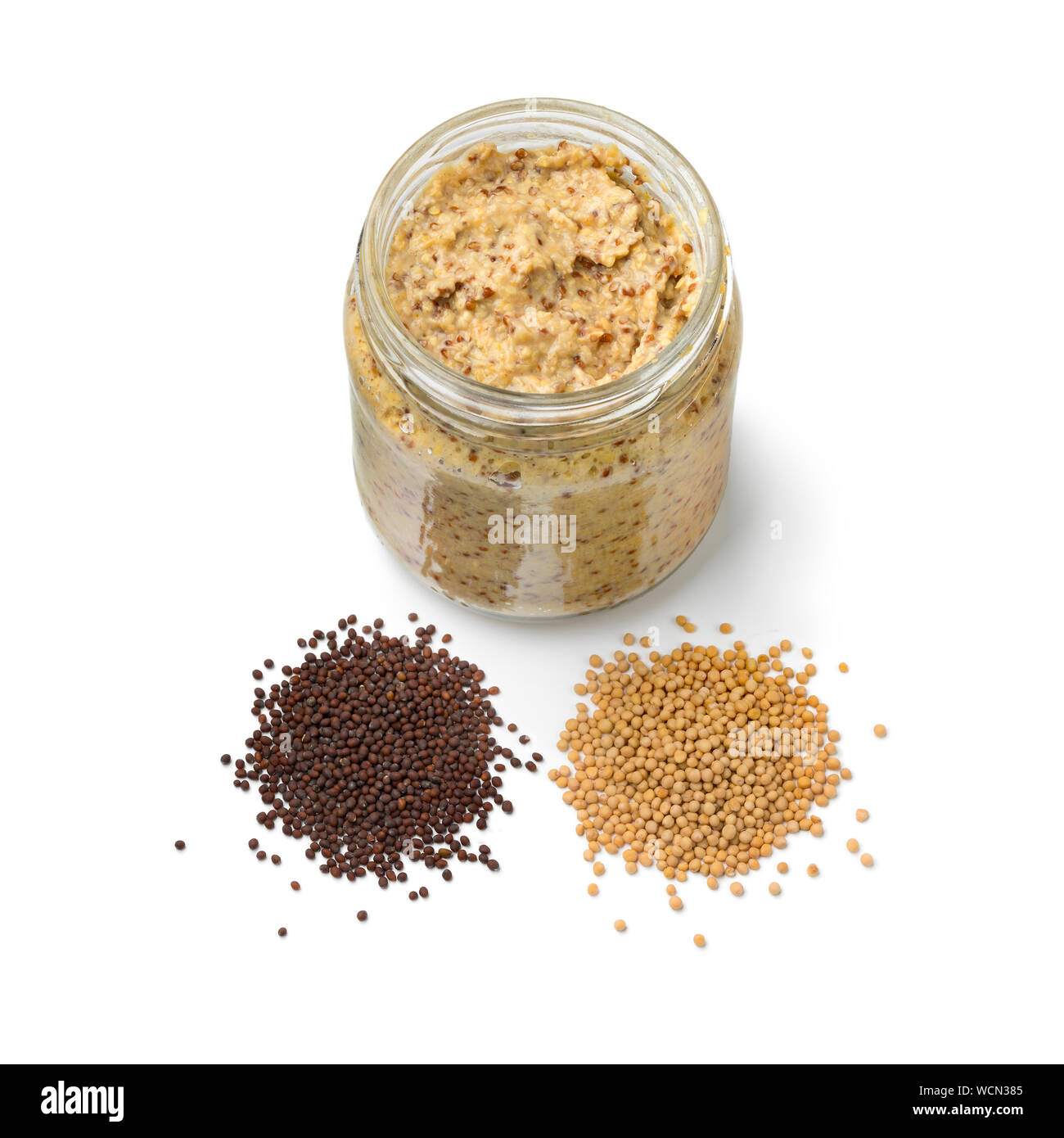 Traditional Dutch mustard with a heap of yellow and brown mustard seed isolated on white