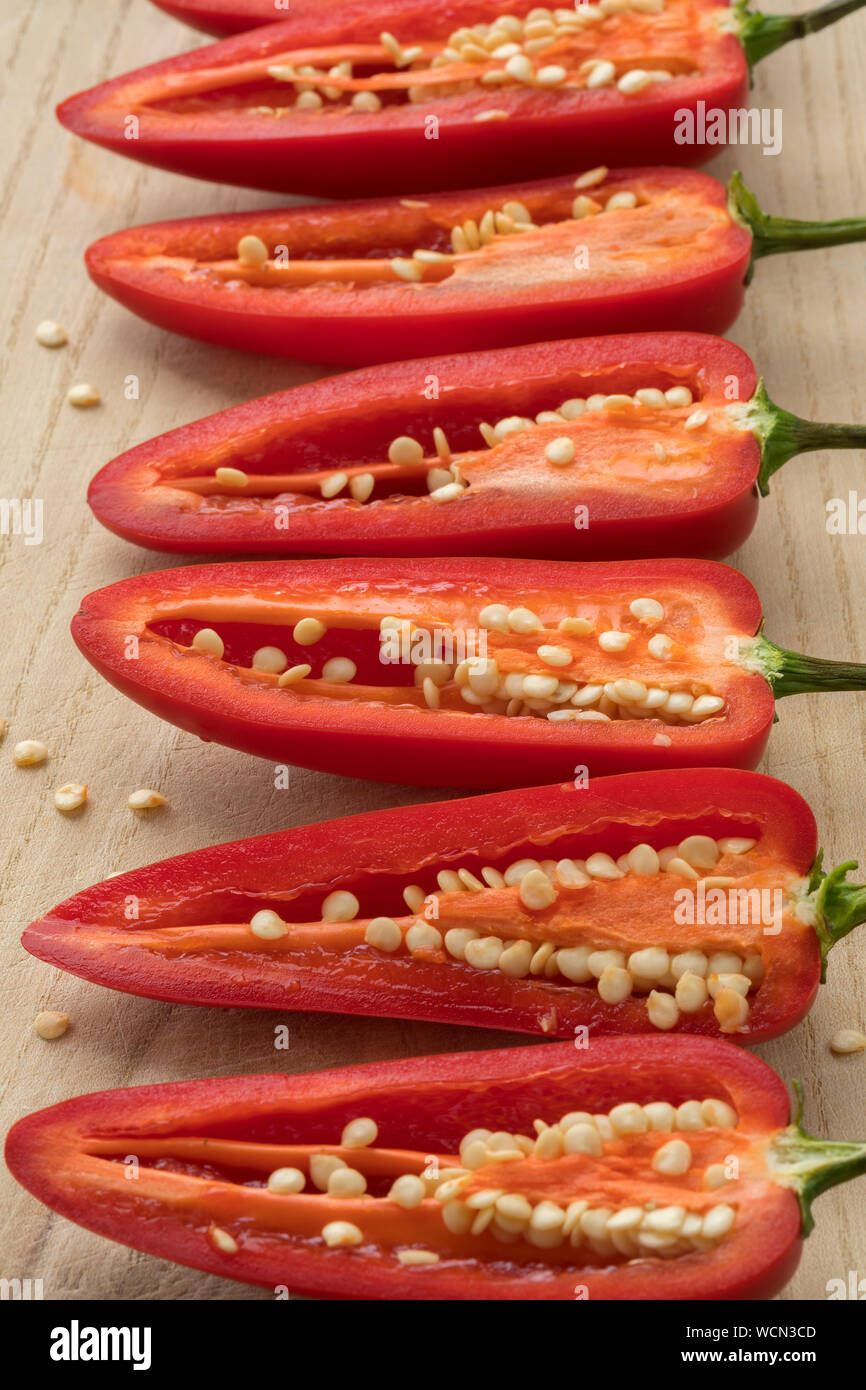 Row of halved red Jalapeno pepper with seeds Stock Photo