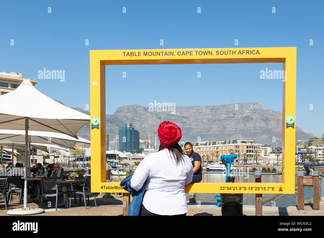 Two African women tourists photgraphing themselves at the yellow frame